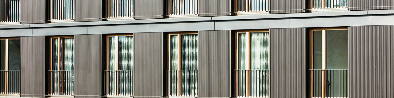La façade profilée en aluminium et les fenêtres de la construction vues de près.