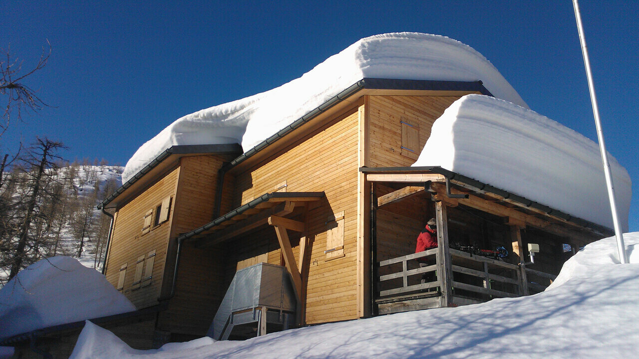 Cabane Capanna Buffalora avec plusieurs centimètres de neige sur le toit.  