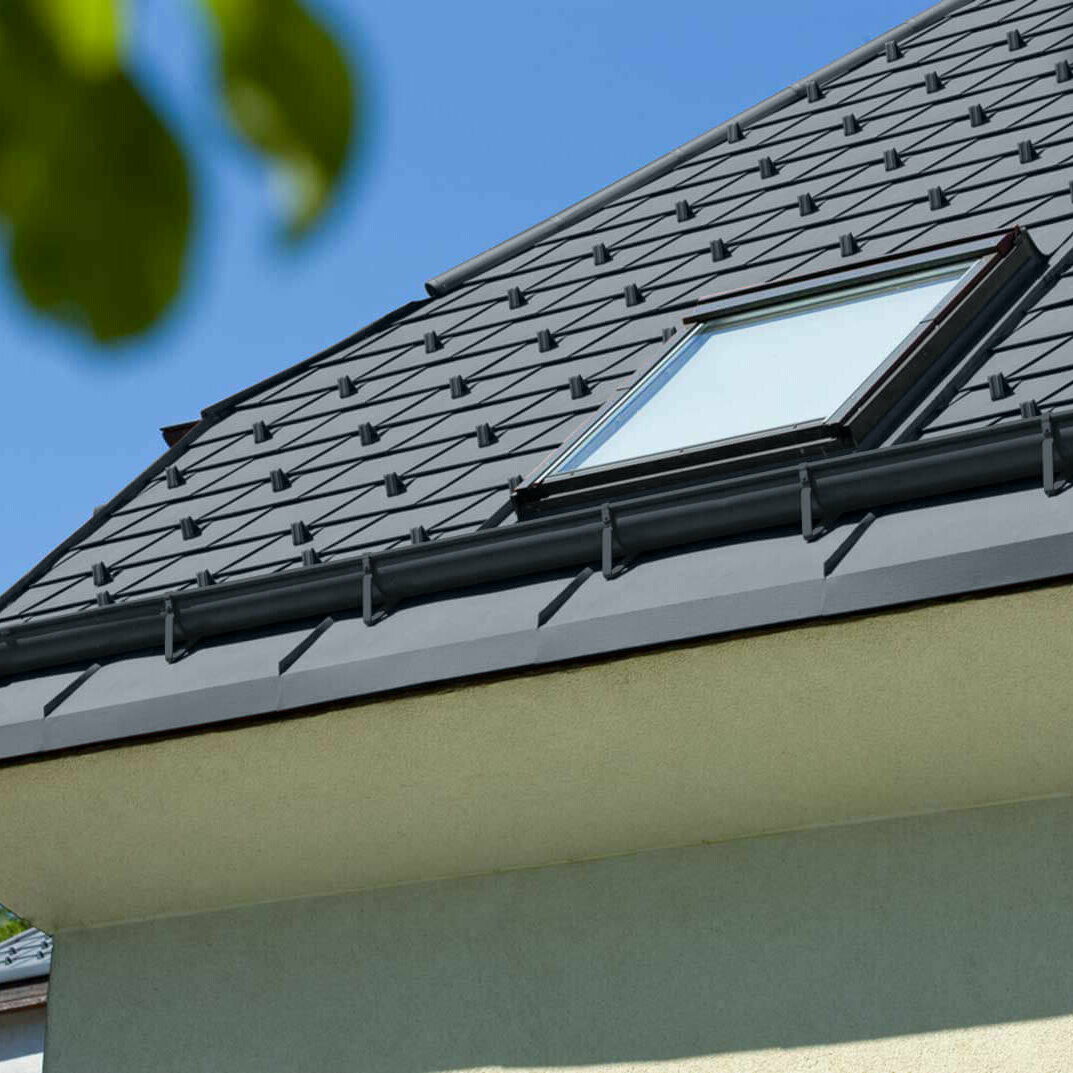 Gros plan d'une maison avec gouttière havraise PREFA en anthracite