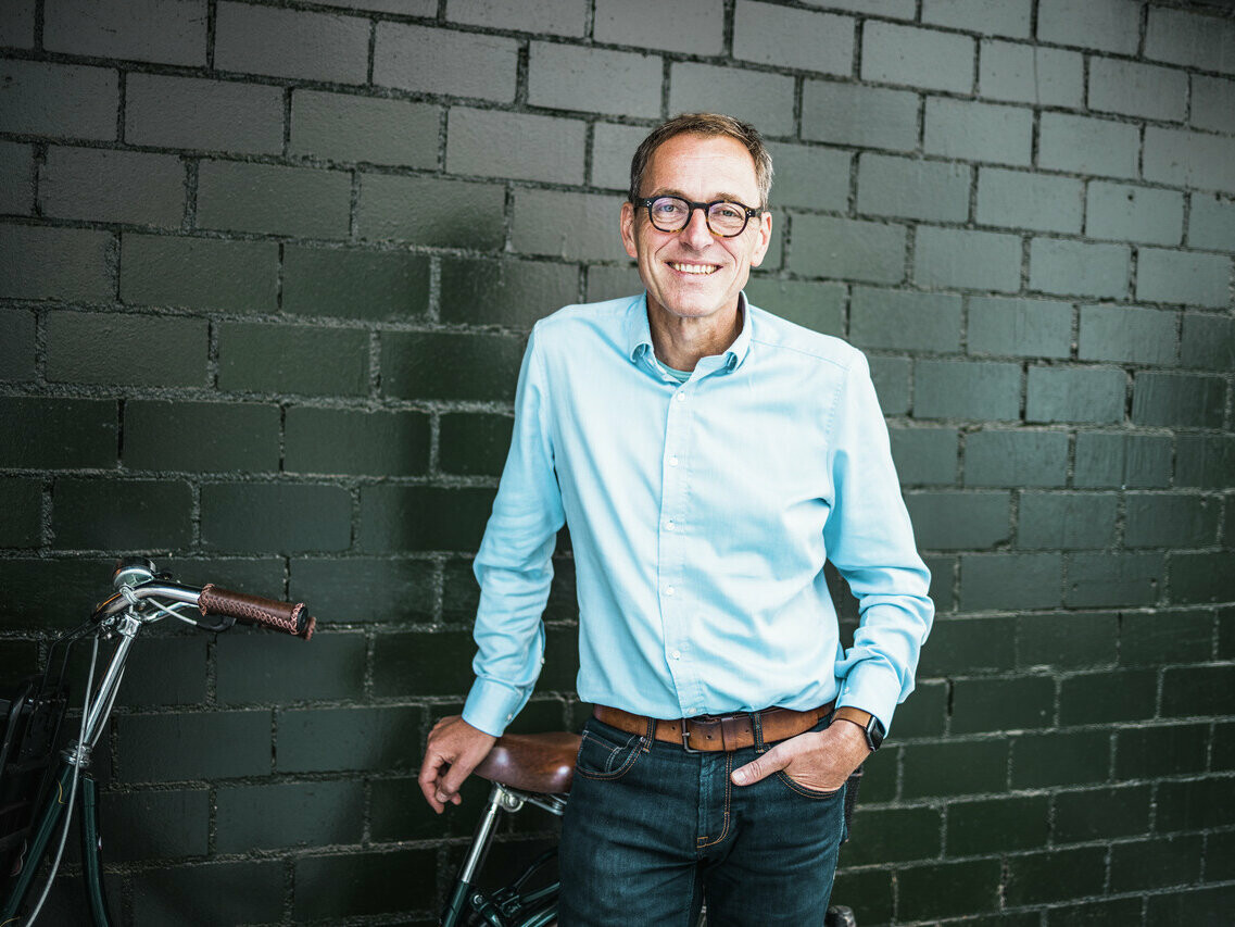 Portrait de l'architecte Jochen Weissenrieder, souriant, dans son bureau.