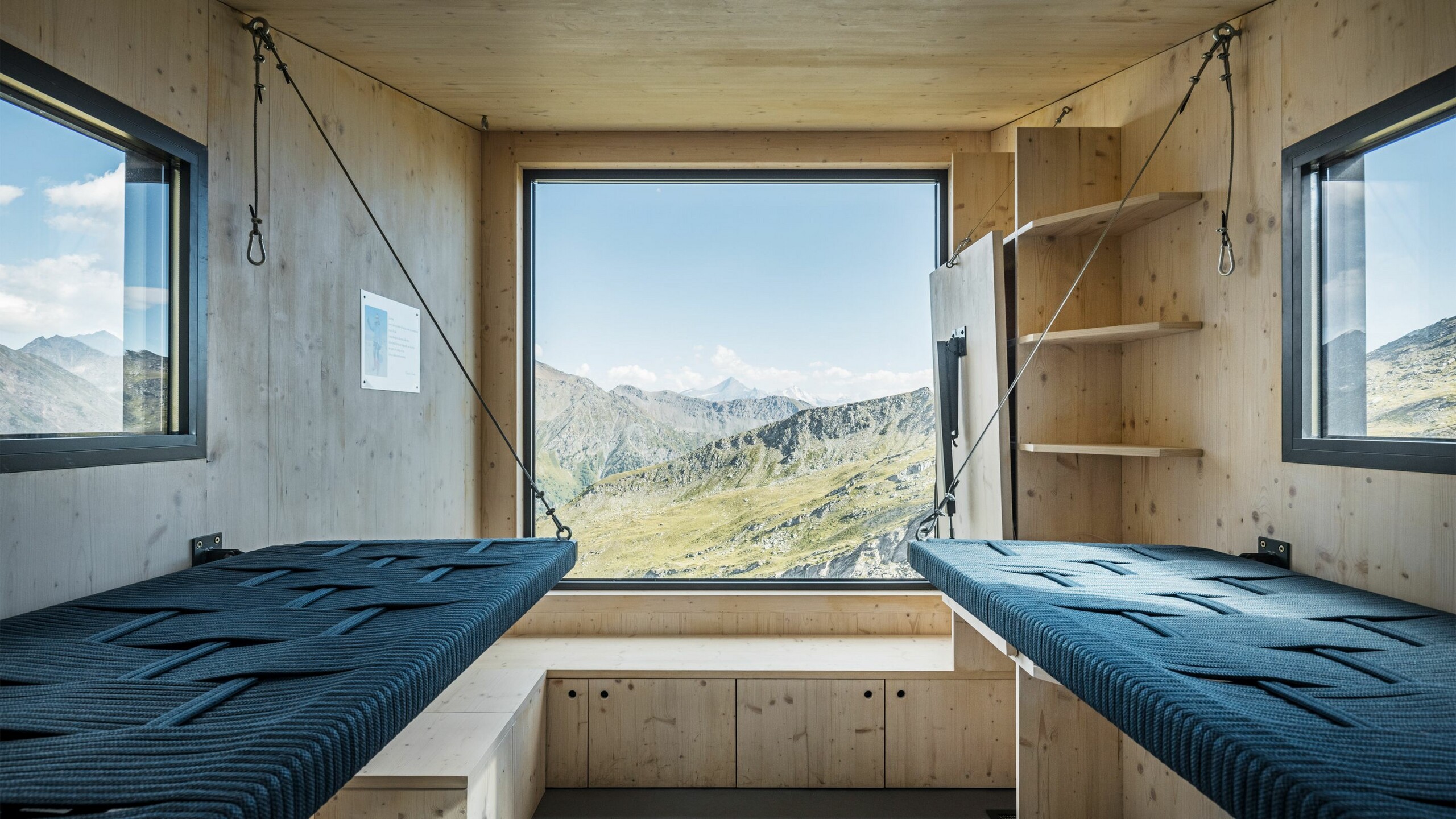 [Translate to Italiano:] Blick ins Interieur samt Schlaf- und Ablagemöglichkeiten, die Fenster gewähren einem einen weitreichenden Blick auf die atemberaubende Naturkulisse.