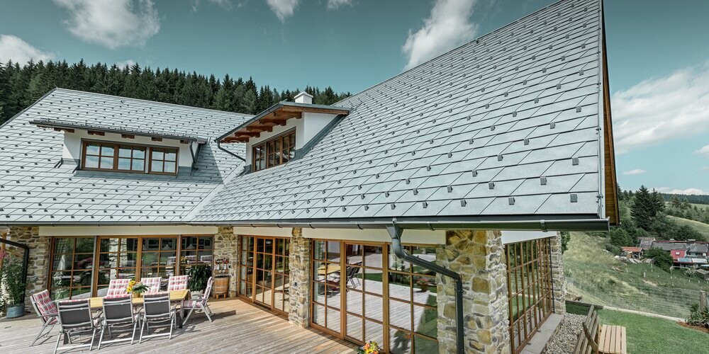 Maison individuelle recouverte de bardeaux de toiture PREFA couleur P.10 gris pierre