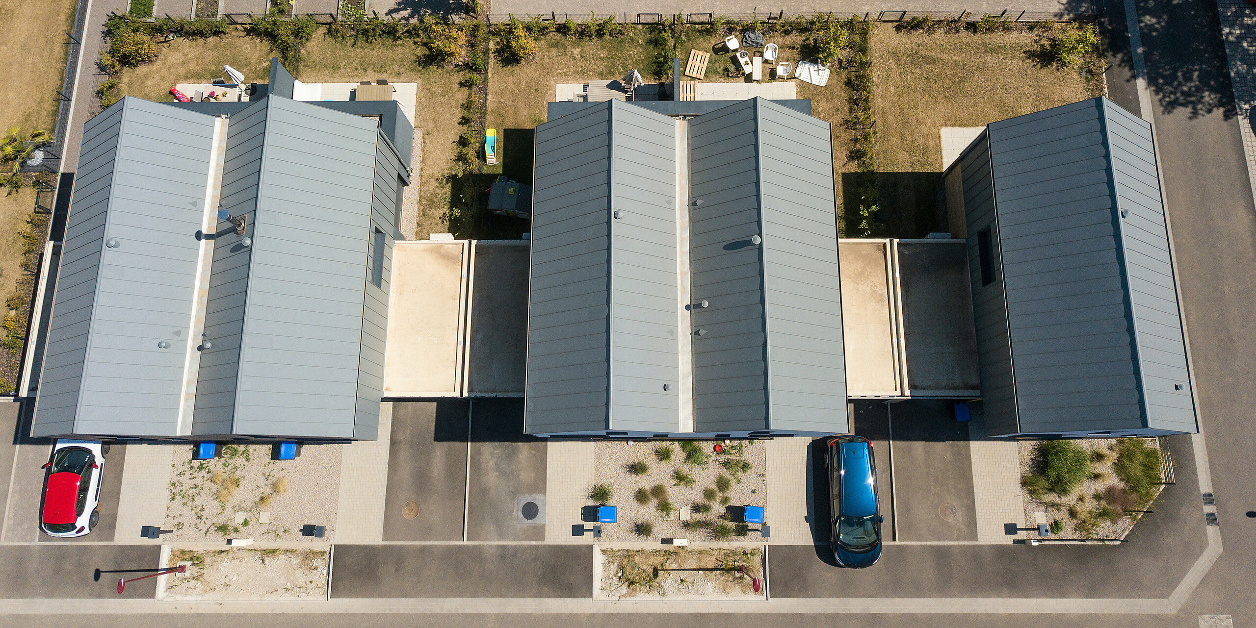 Le joint debout PREFALZ en gris souris s'étend sur les façades et les toits à pignon d'un lotissement mitoyen à Mundolsheim. Les coques uniformes du bâtiment en aluminium créent une image globale harmonieuse.