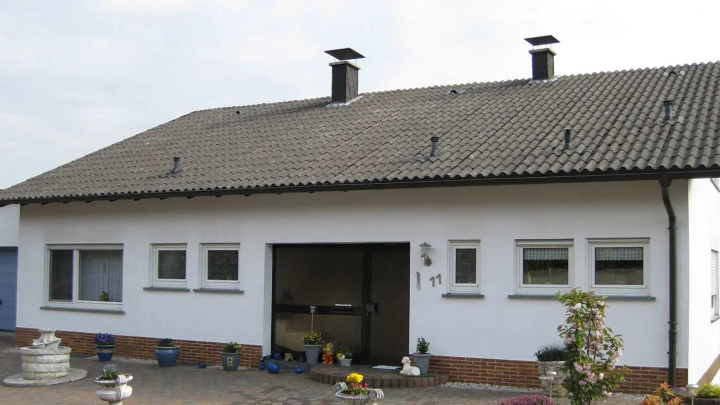 Casa monofamiliare con tetto ondulato in fibrocemento prima della ristrutturazione con tegole PREFA