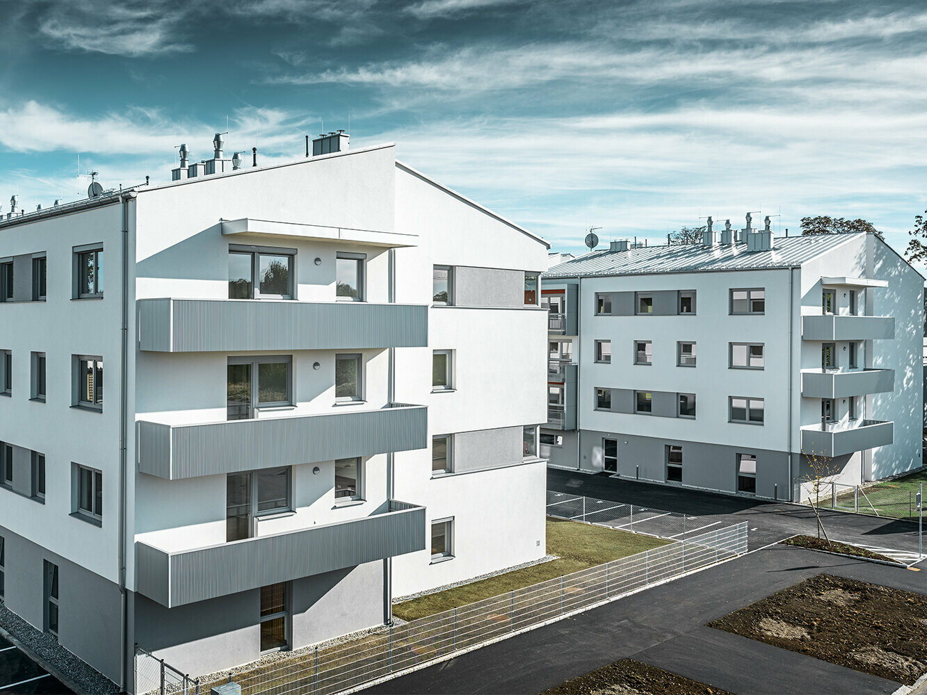 Moderno condominio con facciata bianca e balconi con profilo a zeta PREFA in silver metallizzato
