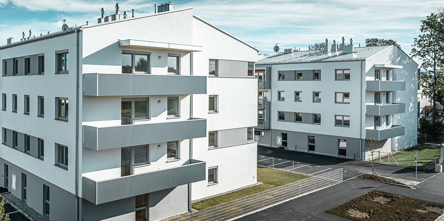 Moderno condominio con facciata bianca e balconi con profilo a zeta PREFA in silver metallizzato