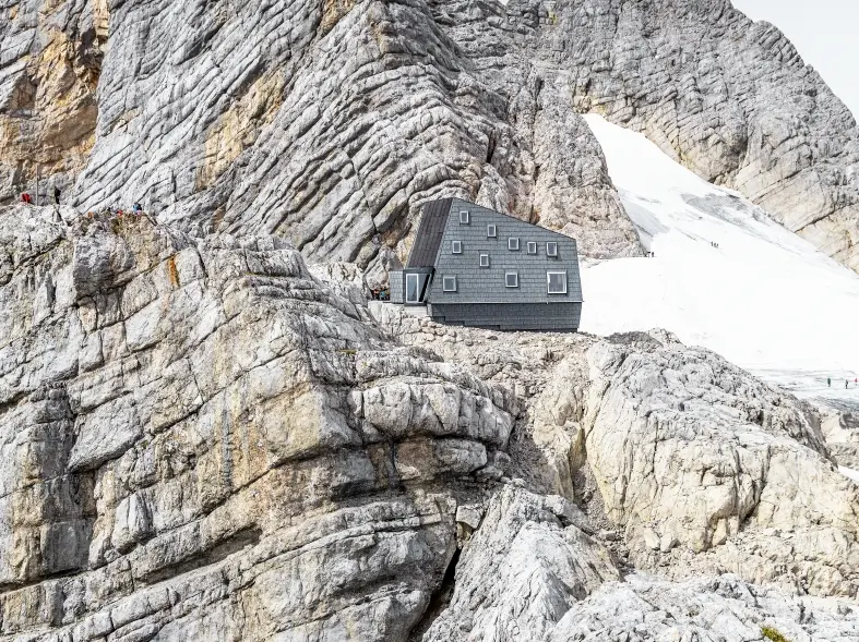die Seethalerhütte auf 2.740 Meter inmitten der Felsen des Dachsteinmassivs, verkleidet mit PREFA Dach- und Fassadenpaneelen FX.12 in P.10 Steingrau