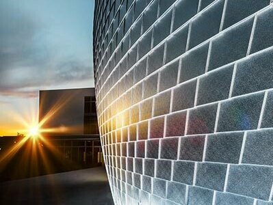 Sonnenspiegelung an den naturblanken Wandschindeln der Sporthalle in Tschechien