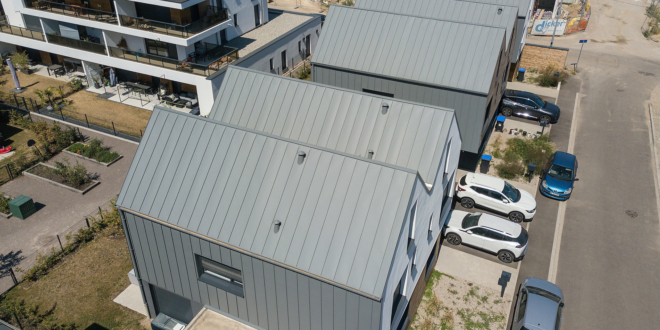Le joint debout PREFALZ en gris souris s'étend sur les façades et les toits à pignon d'un lotissement mitoyen à Mundolsheim. Les coques uniformes du bâtiment en aluminium créent une image globale harmonieuse.