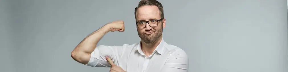 Regionalleiter, Christian Wirth, zeigt seine Muskeln und symbolisiert dadurch Stärke.