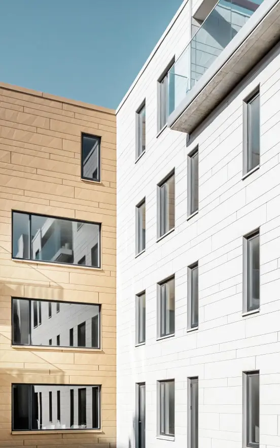 Moderne Gebäude mit PREFA Siding.X Fassade in zwei Farben, die das innovative Fassadenmaterial und die moderne Architektur betonen.