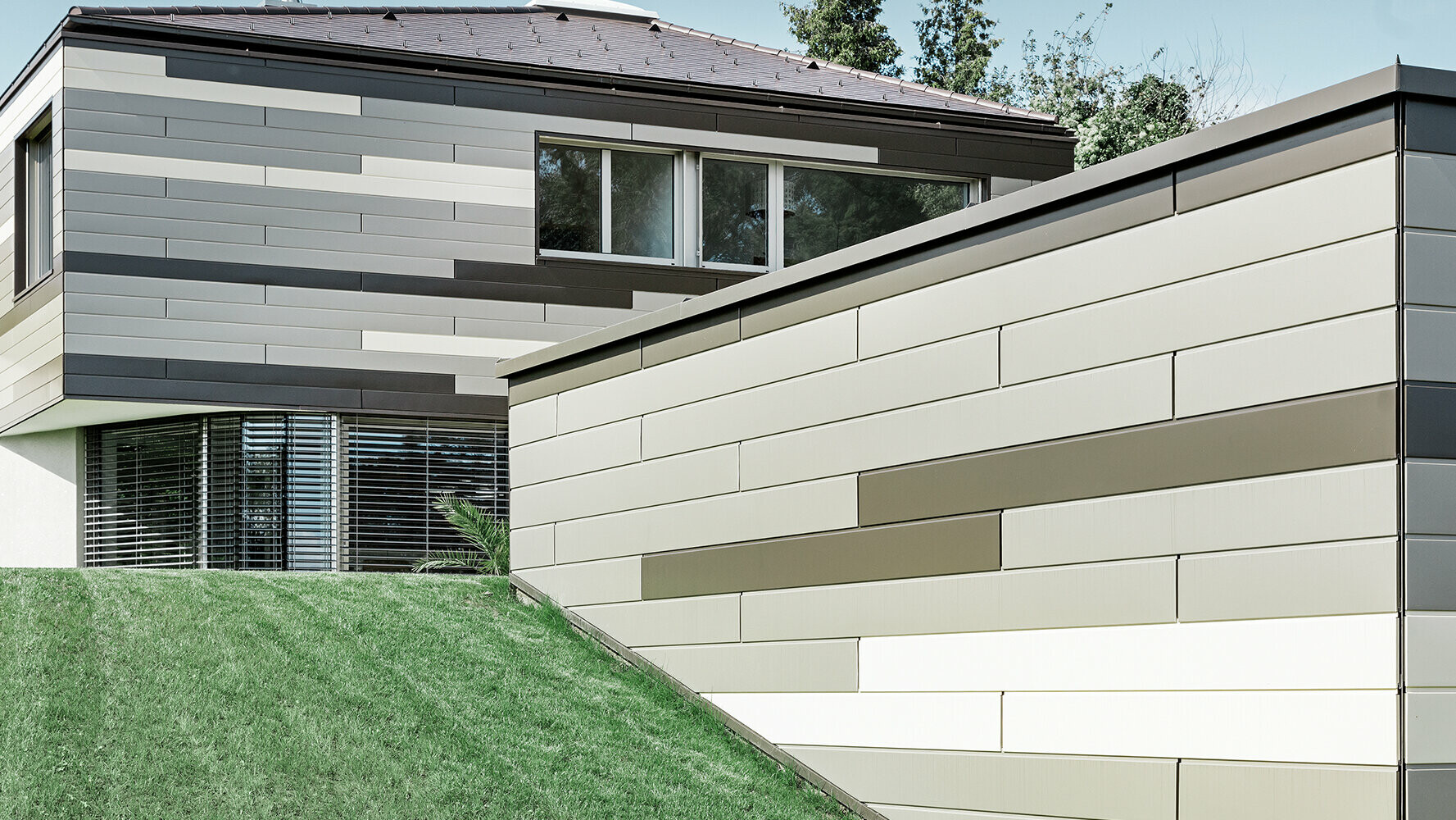 Maison moderne avec façade revêtue de Sidings PREFA dans trois différentes couleurs