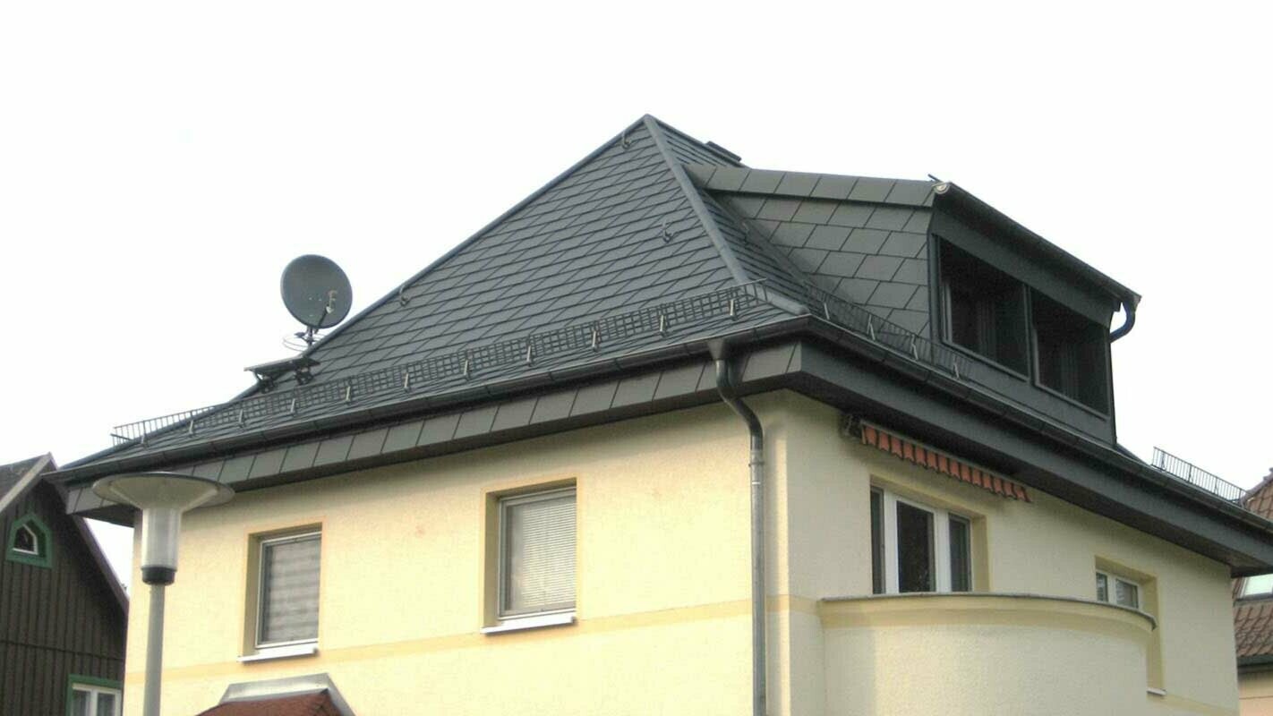 Walmdach Dachsanierung mit der PREFA Dachschindel und Gaube, gelbe Fassade