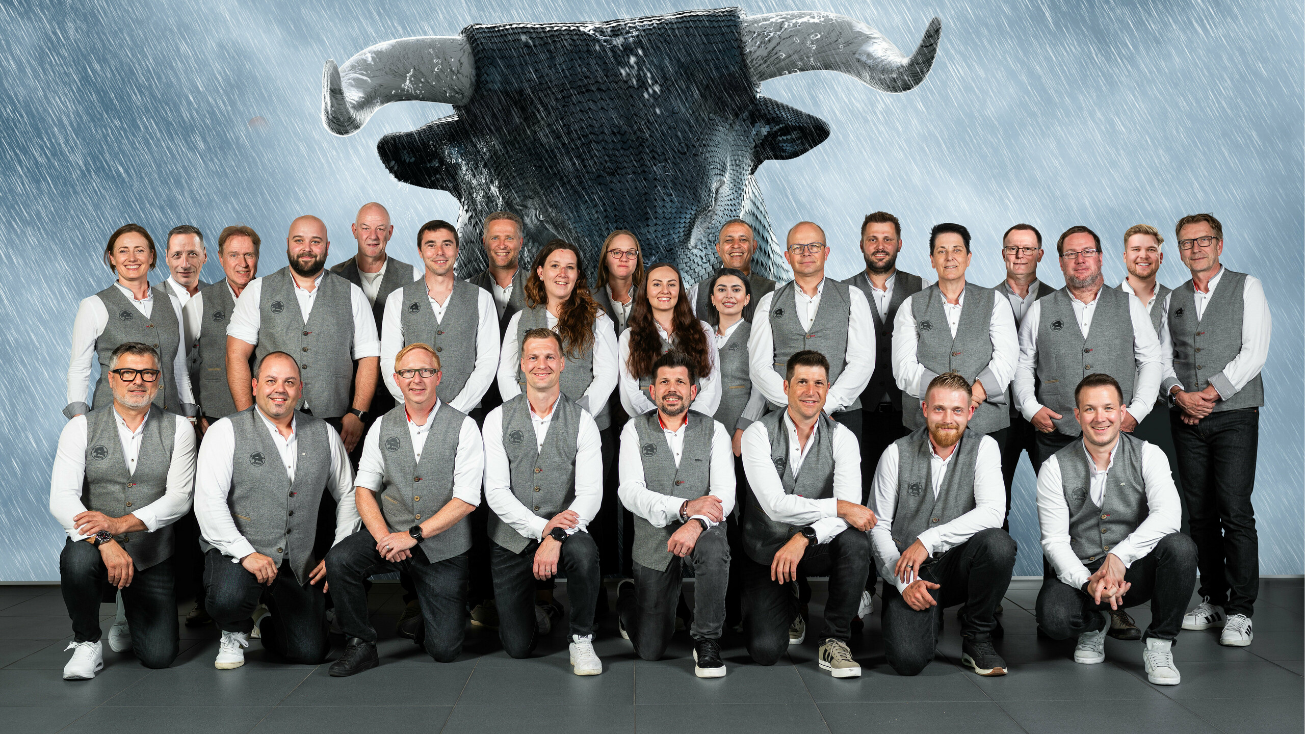 Collaborateurs PREFA de Suisse devant un écran sur lequel on peut voir le taureau PREFA.