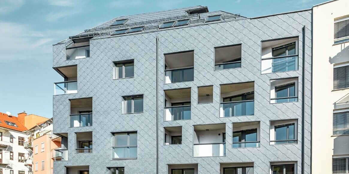 Vue de la maison à Graz, avec sa façade revêtue de losanges 44 x 44 PREFA dans la couleur P.10 gris pierre.
