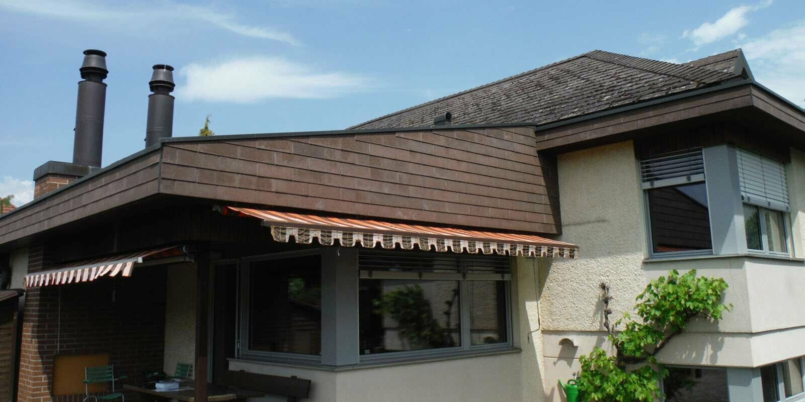 Casa monofamiliare con giardino d’inverno e ampliamento dopo la ristrutturazione del tetto con tegole PREFA