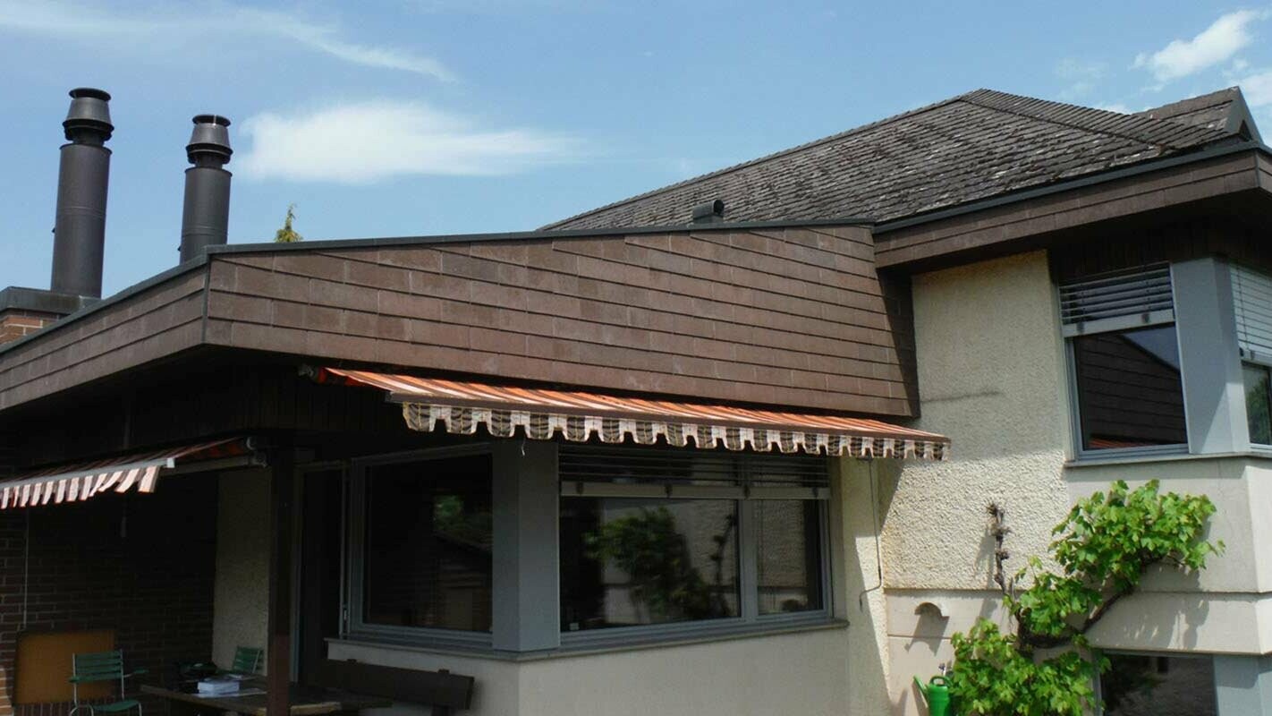 Maison individuelle avec fibrociment ondulé avant la rénovation de toiture à l’aide de tuiles PREFA