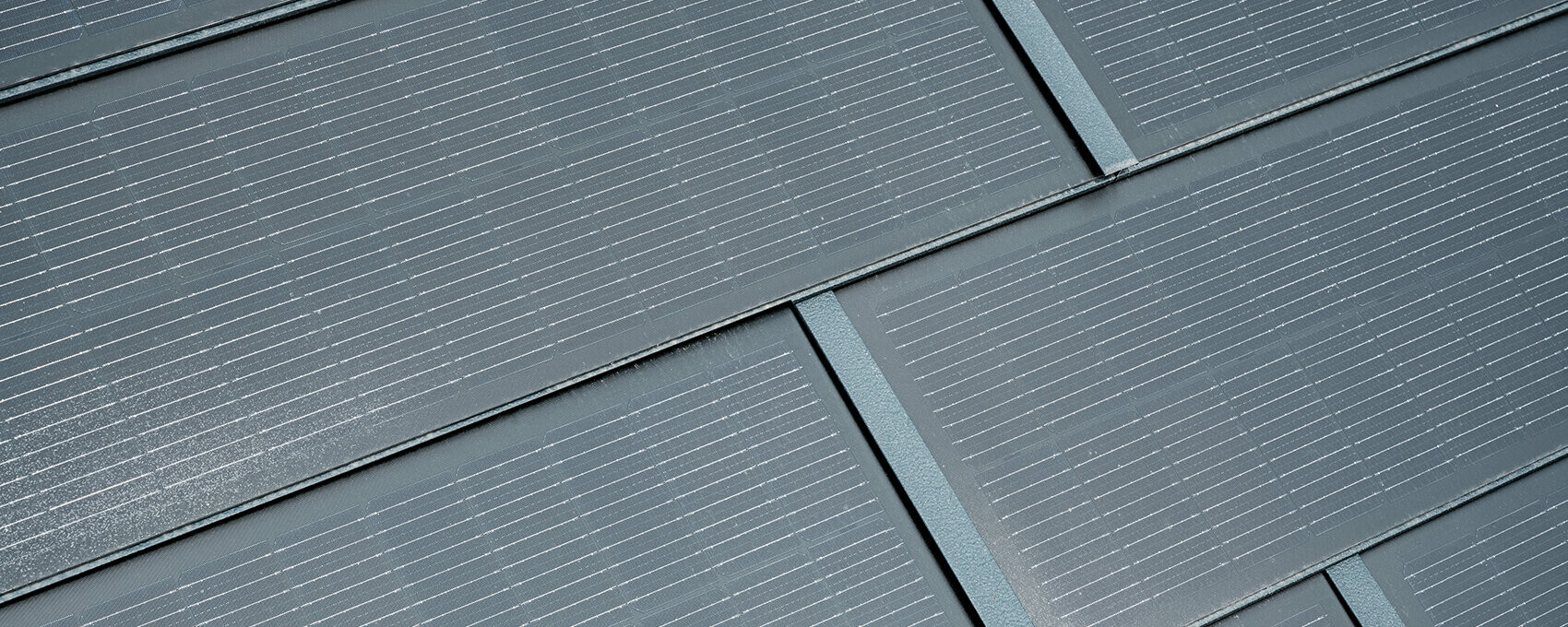 Detailaufnahme der verlegten PREFA Solardachplatte. Die Solardachplatte in der Farbe P.10 Anthrazit wurde mit der Dachplatte R.16 kombiniert. 