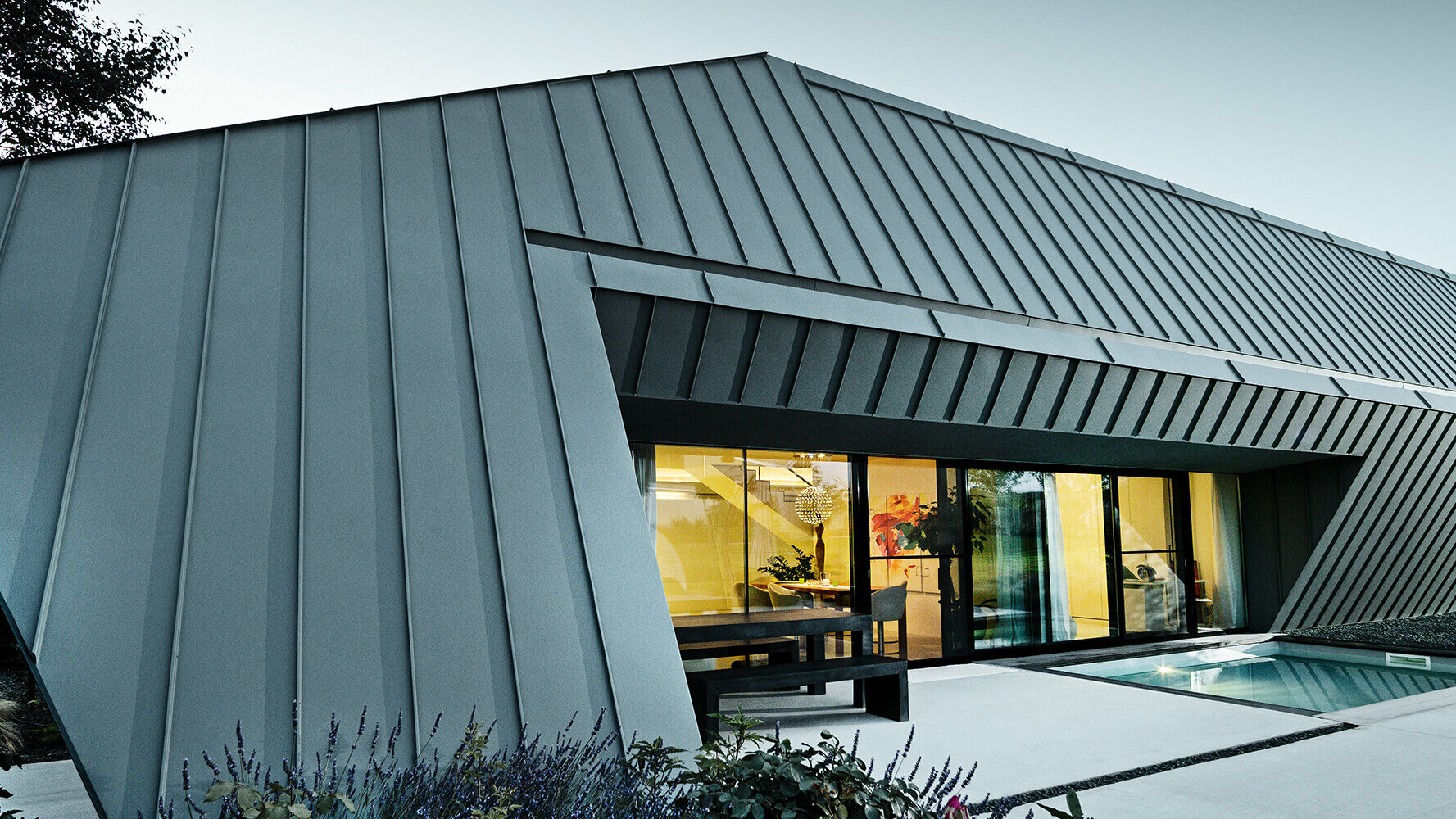 Casa unifamiliare di nuova costruzione con tetto e facciata in alluminio di PREFA nei colori P.10 antracite e P.10 grigio chiaro.