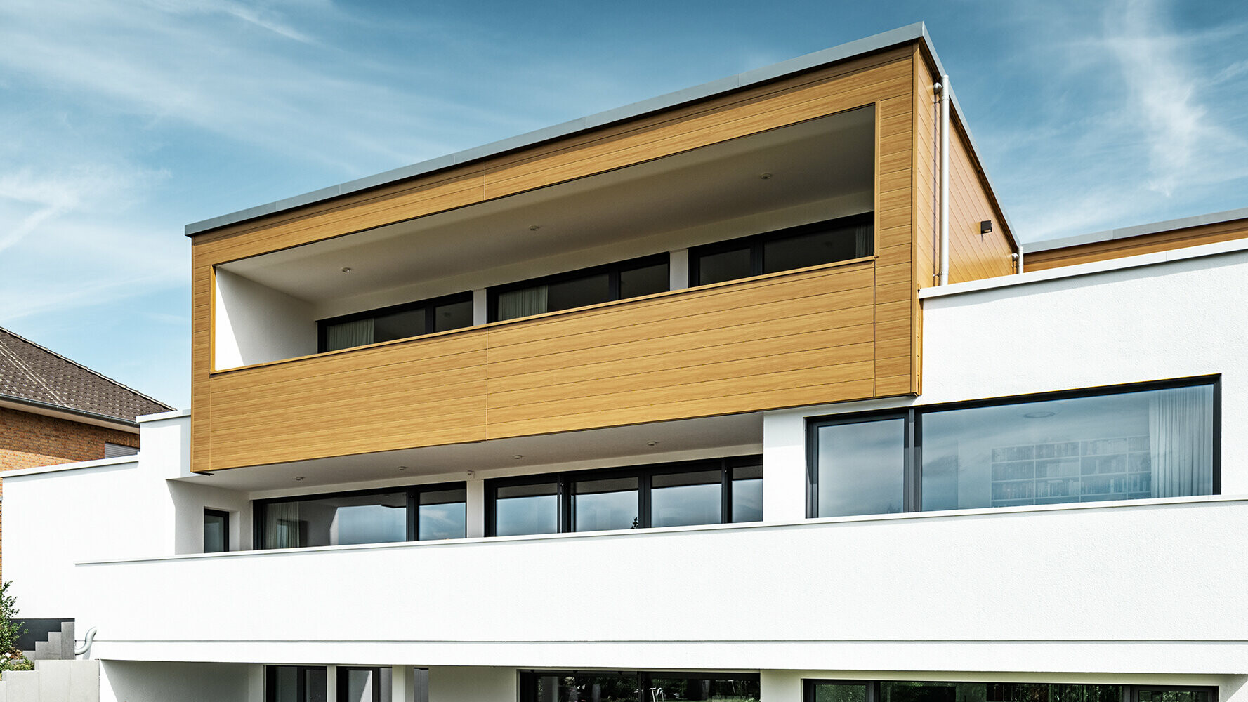 Edificio residenziale moderno con vetrata, rivestito in Doghe PREFA colore rovere grigio