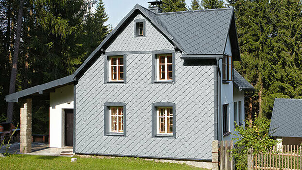 Fassadensanierung mit der Wandraute von PREFA Einfamilienhaus mit dem PREFA Komplettsystem; Die Fassade ist mit der PREFA Wandraute 29 in Hellgrau eingedeckt.