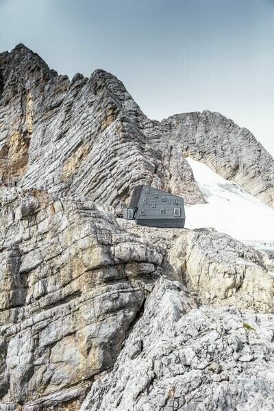 Il rifugio Seethalerhütte a 2.740 metri nel cuore del paesaggio roccioso del monte Dachstein, rivestito in copertura e facciata con i pannelli FX.12 PREFA P.10 grigio pietra