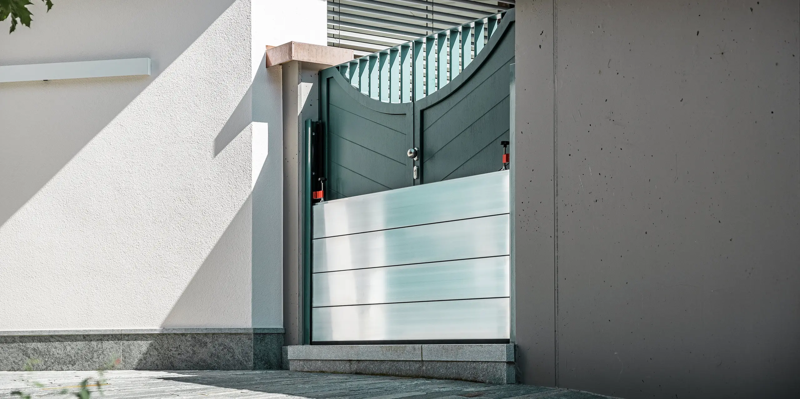 Nahaufnahme eines montierten PREFA Hochwasserschutzsystems am Gartentor eines Einfamilienhauses in Schwaz, Tirol. Die eingesetzten Dammbalken aus Aluminium sind in seitlich angebrachte Befestigungsprofile eingeschoben und schützen den Eingangsbereich zuverlässig vor eindringendem Wasser. Das System überzeugt durch seine schlichte Optik, die schnelle Einsatzbereitschaft und die korrosionsbeständigen Materialien - ideal für den privaten Objektschutz. Die Wandprofile sind in der gleichen Farbe wie die Tür gehalten, so dass ein harmonischer Gesamteindruck entsteht.
