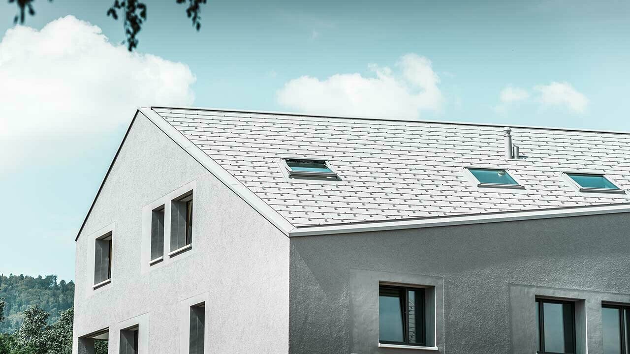 Immeuble d’habitation avec égout oblique et panneau de toiture FX.12 blanc.