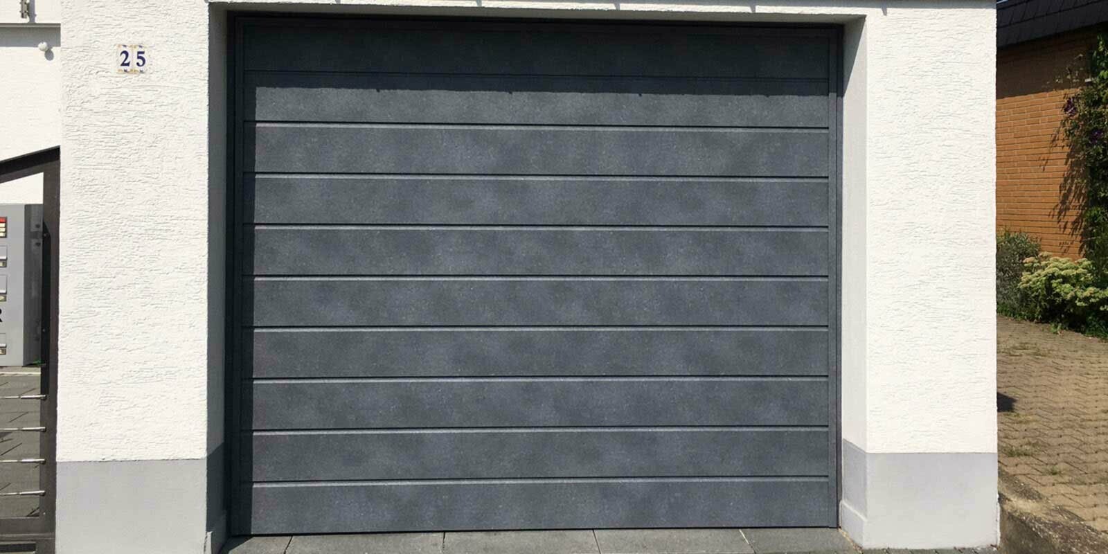 Portone del garage con doghe di rivestimento PREFA color grigio pietra in posa orizzontale