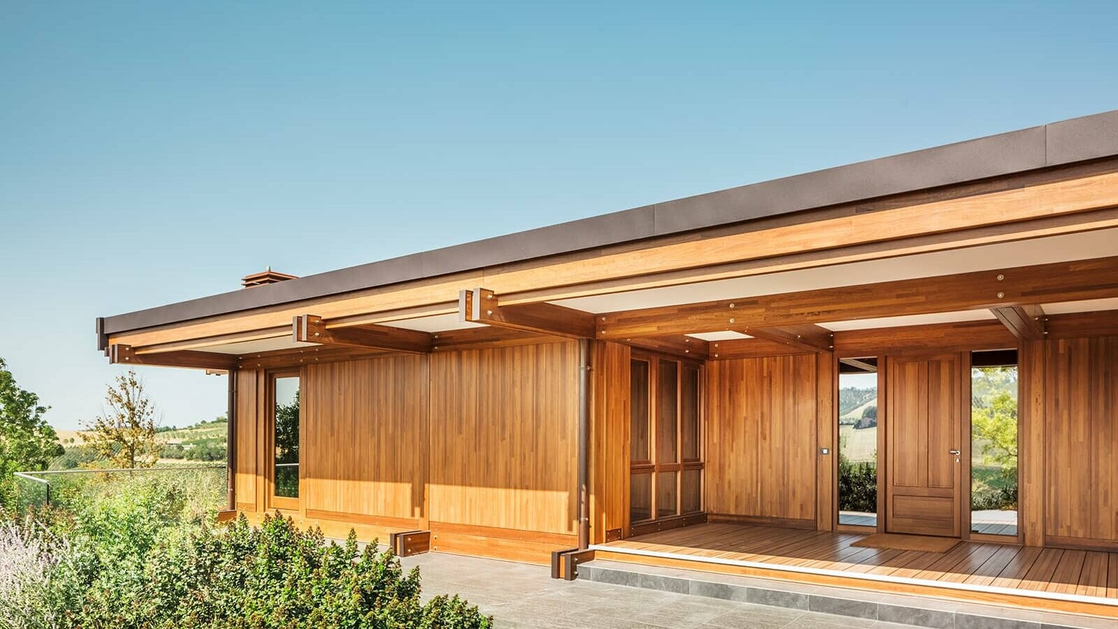 Das Musterhaus von Pagano. Das Dach ist mit Prefalz in der Farbe Nussbraun eingedeckt, der Rest des Hauses ist aus Holz gefertigt.