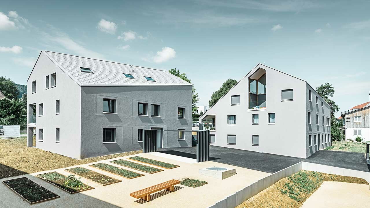 Bâtiments d’habitation avec égout oblique avec le panneau de toiture FX.12 PREFA en blanc.