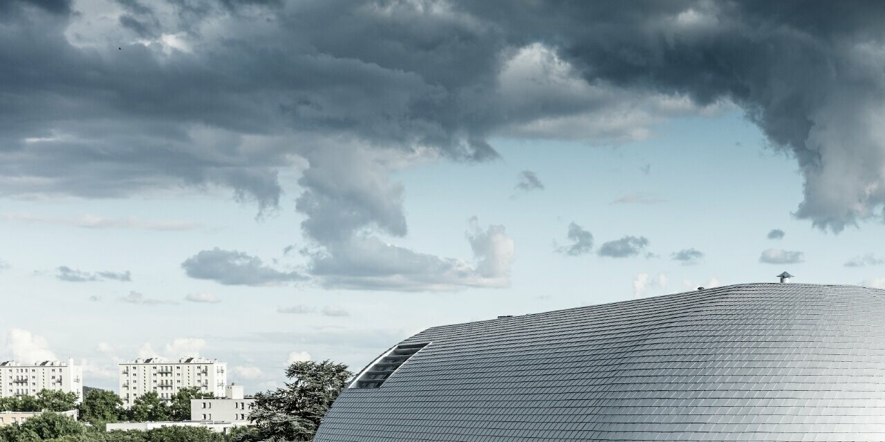 Edificio aziendale con cupola rotonda e scandole in alluminio PREFA rivestite in silver metallizzato;