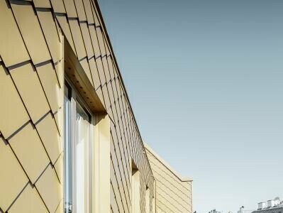 Extravagante Lösung für einen Wiener Dachgeschossausbau mit PREFA Rauten in Perlgold