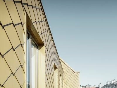 Extravagante Lösung für einen Wiener Dachgeschossausbau mit PREFA Rauten in Perlgold