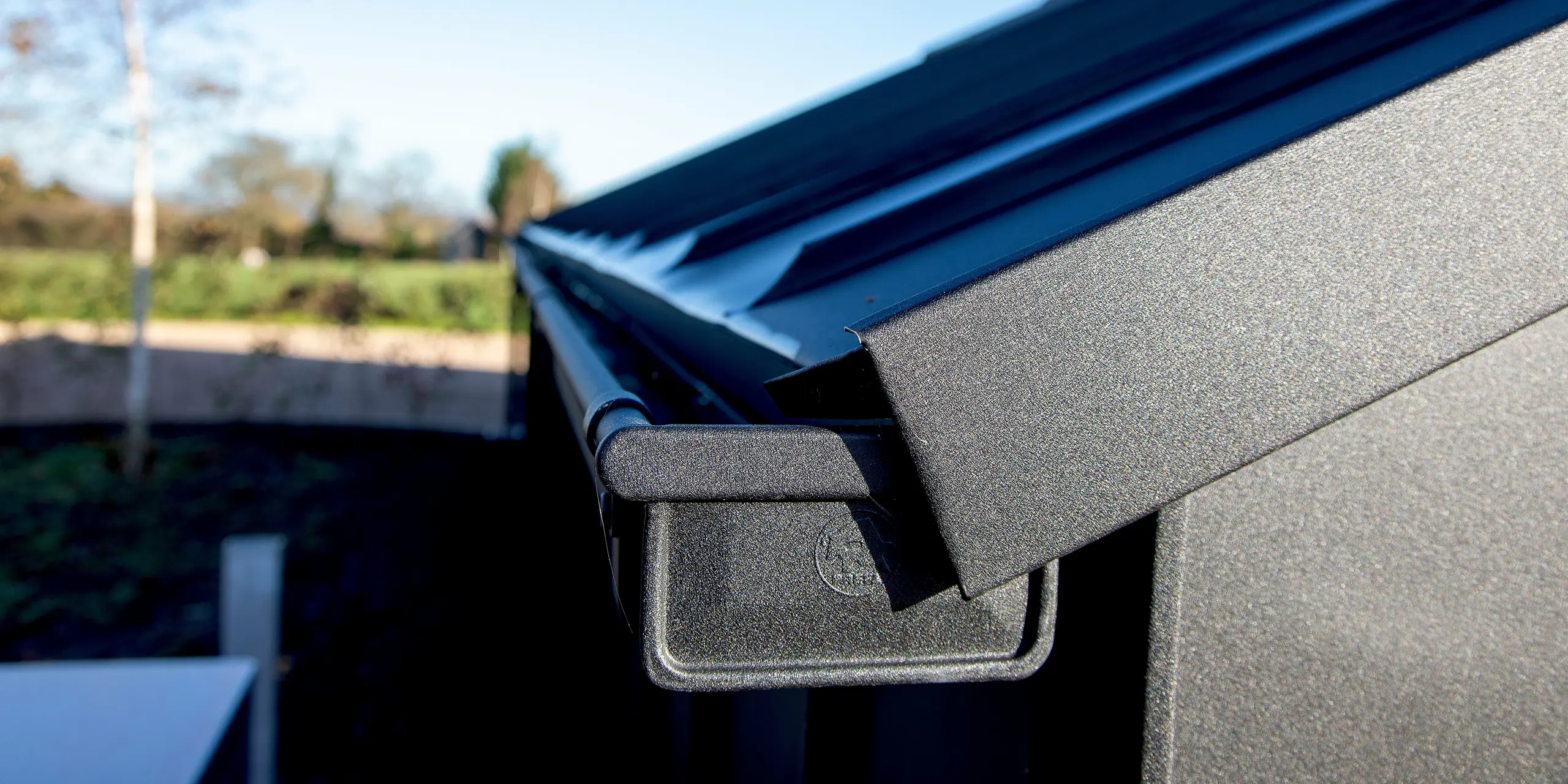 Gros plan sur une toiture PREFA moderne avec PREFALZ en P.10 noir. La gouttière en aluminium de précision et le revêtement de toiture robuste créent des lignes épurées et une apparence haut de gamme. La surface en aluminium durable et résistante aux intempéries assure une stabilité maximale et une esthétique architecturale remarquable.