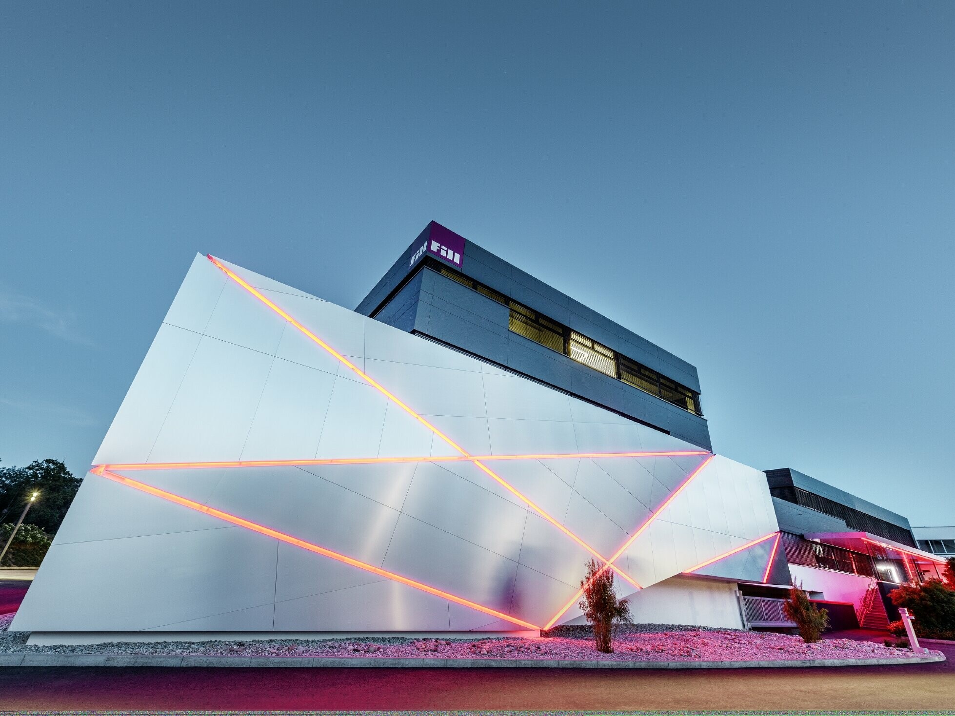 Edificio aziendale di Fill con una facciata futuristica in pannello composito in alluminio spazzolato e fughe retroilluminate