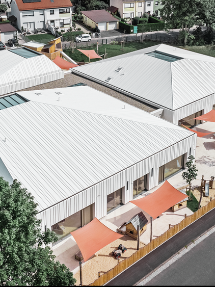 Les "trois sommets enneigés" de l'école évangélique léthéenne de Niederwern dont la toiture est recouverte de Prefalz dans la teinte P.10 blanc pur de chez Prefa  