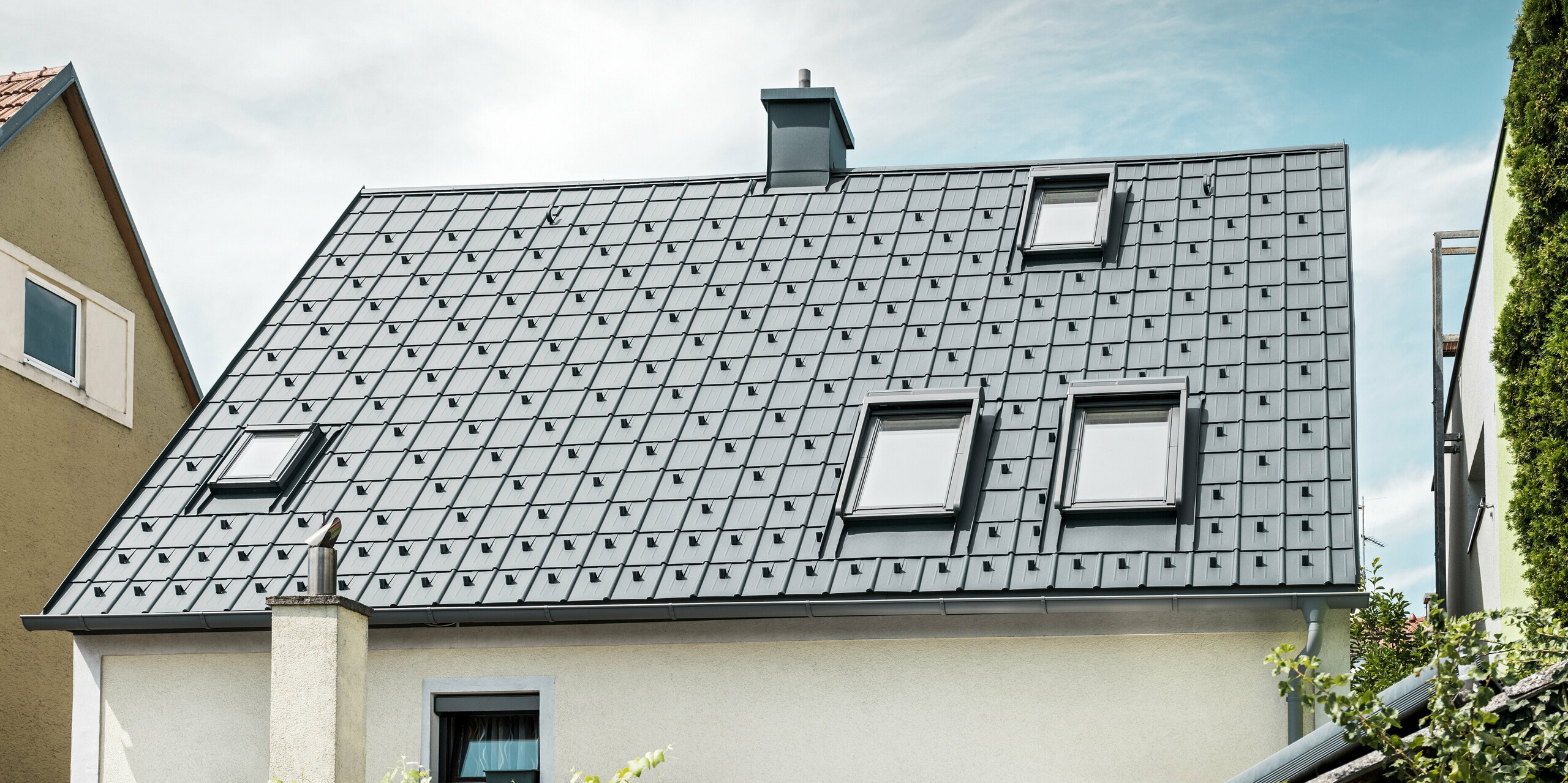 Einfamilienhaus in St. Valentin mit PREFA Dachplatte in anthrazit und einem Dachentwässerungssystem von PREFA in hellgrau