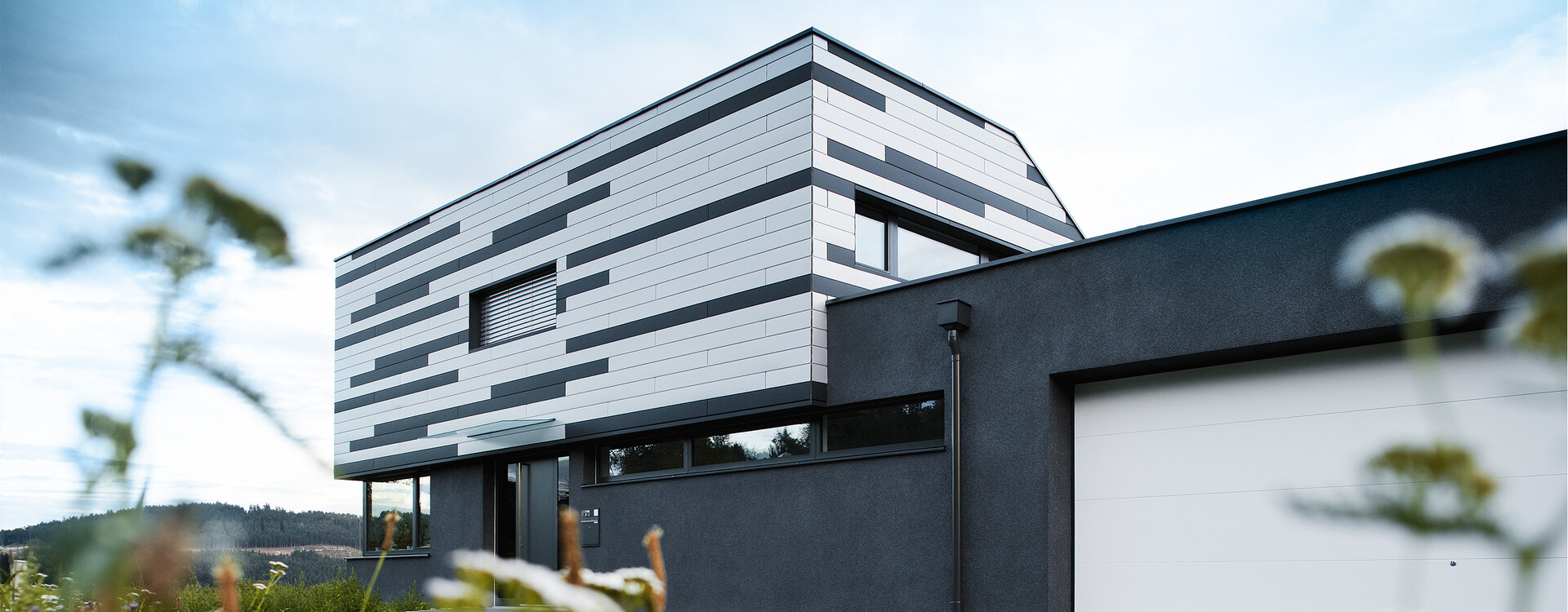 Moderna casa unifamiliare con realizzazione della facciata creativa; le doghe PREFA sono state posate miste in silver e antracite opaco.