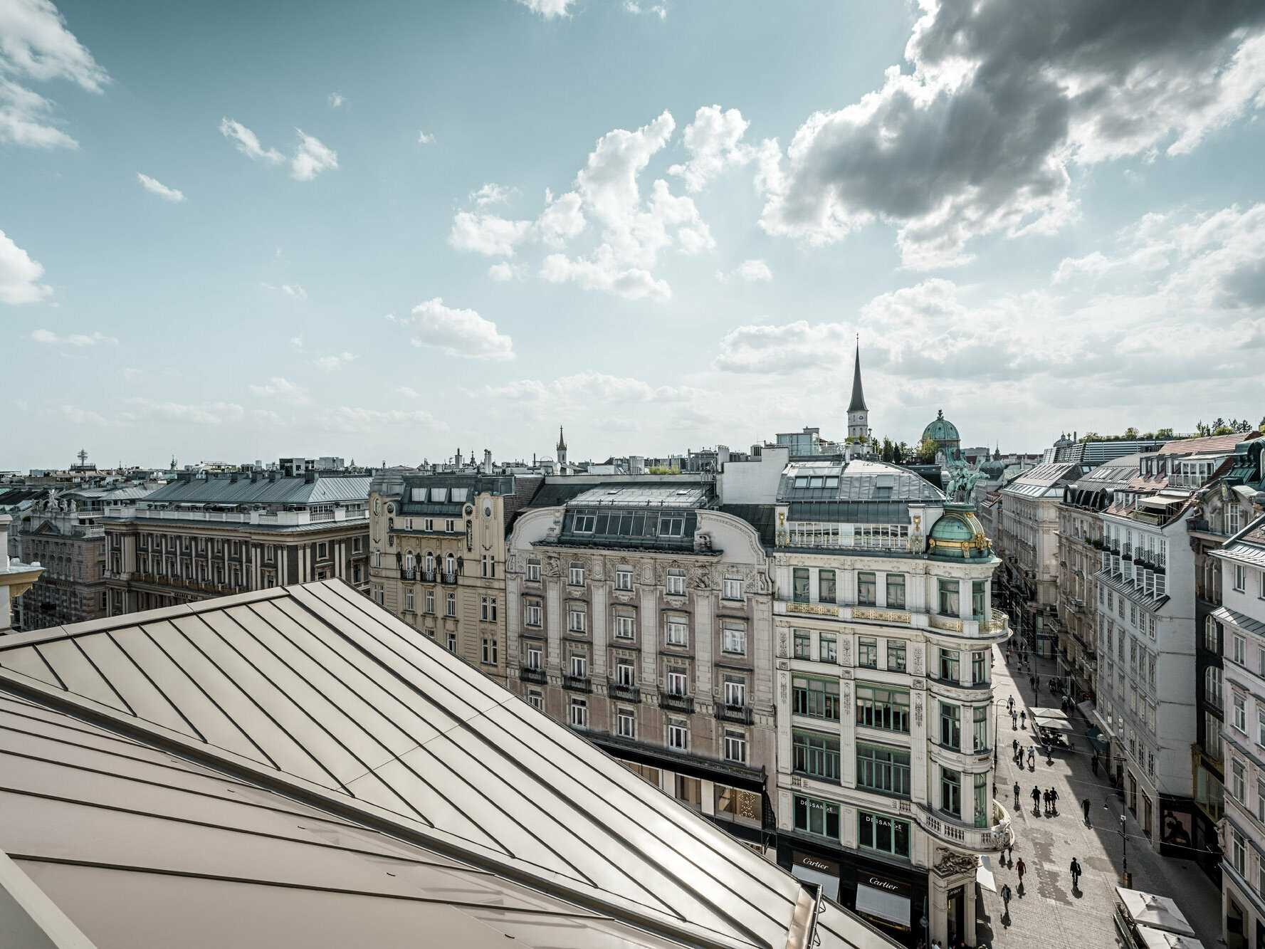 Vue large sur les toits de Vienne, avec à gauche les bandes Prefalz à l’élégante couleur bronze de l’hôtel Rosewood Vienna.