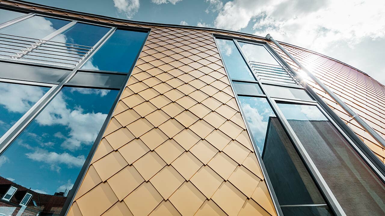 goldene Aluminium Wandraute von PREFA mit großzügigen Fenstern am Schuhhaus Schüttfort in Hamburg-Bergedorf