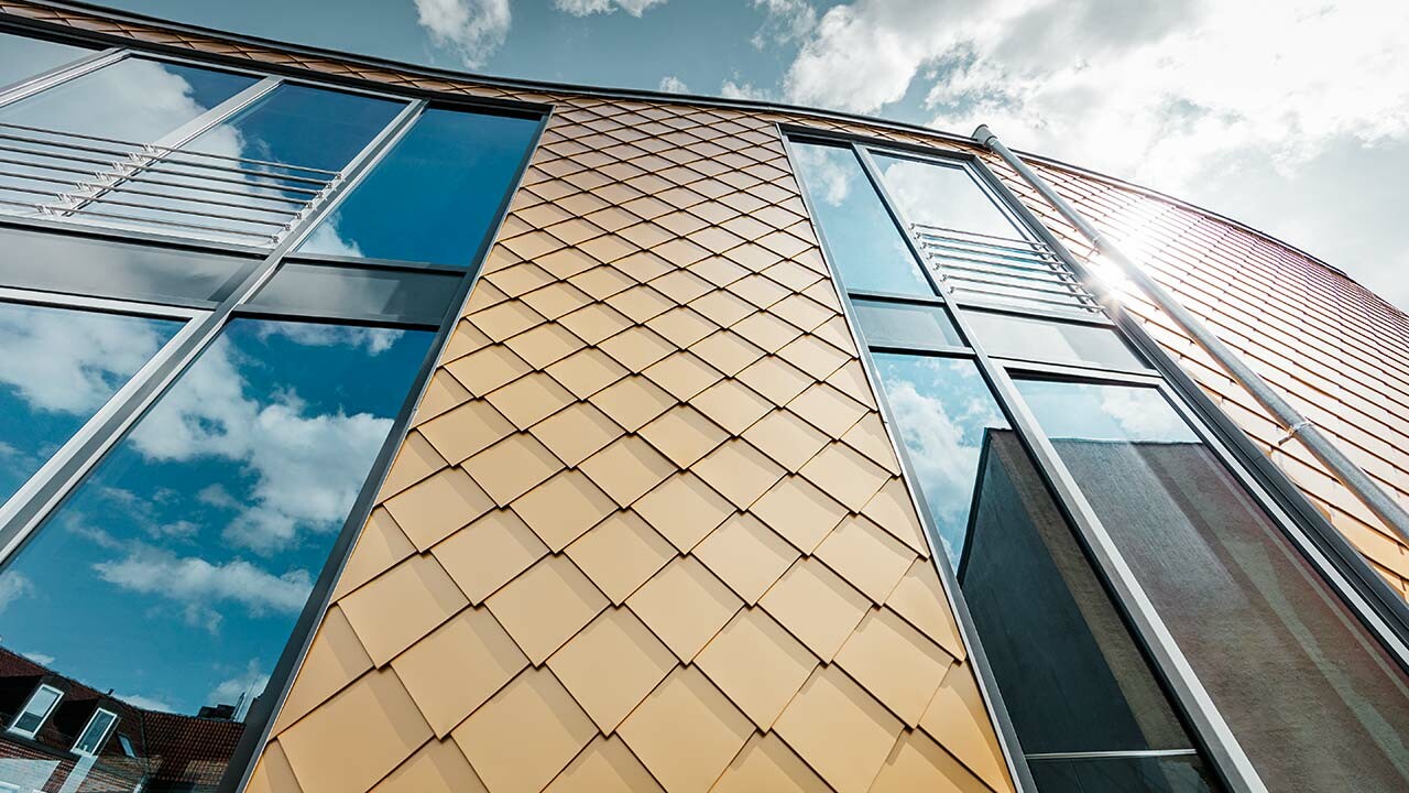 goldene Aluminium Wandraute von PREFA mit großzügigen Fenstern am Schuhhaus Schüttfort in Hamburg-Bergedorf