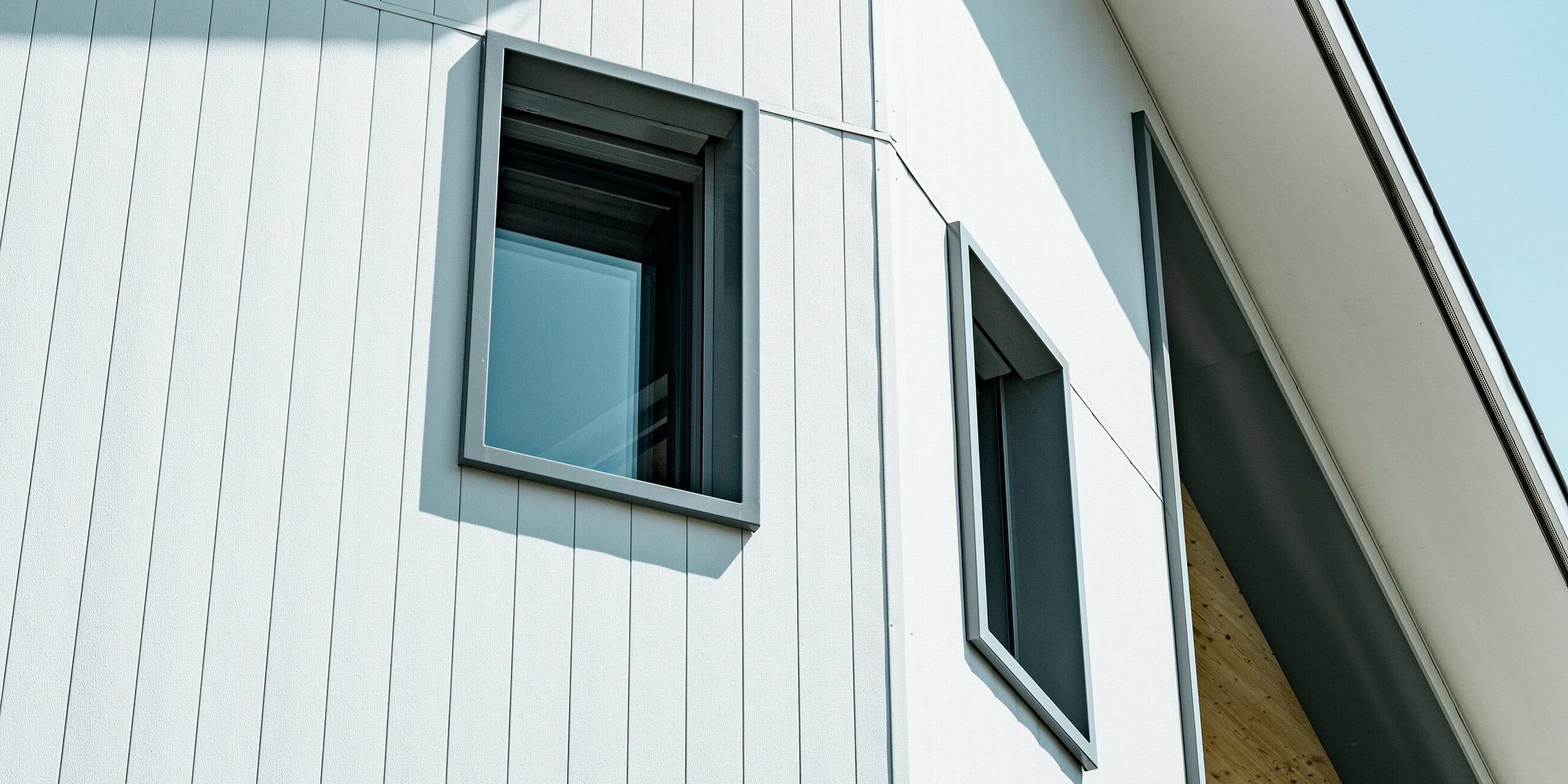 Sidings PREFA en gris pierre P.10 et blanc Prefa P.10 sur les façades de deux immeubles d'habitation voisins à Weissbad, en Suisse.