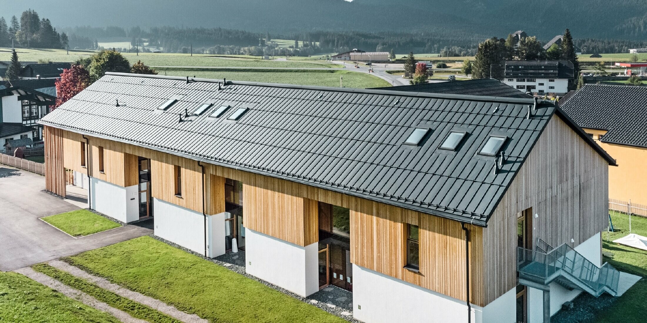 Crèche Kräuterkindergarten à Bad Mitterndorf avec grand toit PREFALZ en P.10 anthracite et façade en bois