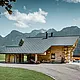 Blockhaus in Gosau, Österreich, mit einem PREFA Dachsystem in der Farbe Anthrazit. Die bewährten Dachplatten R.16 schaffen einen ansprechenden Kontrast zum natürlichen Holz des Blockhauses. Im Hintergrund erstreckt sich ein majestätisches Bergpanorama, das die ruhige und malerische Lage des Hauses unterstreicht. Die detailreiche Aufnahme fängt die Symbiose aus traditioneller Baukunst aus Österreich und moderner Dachtechnologie ein und zeigt die robuste und ästhetische Qualität der PREFA Aluminiumprodukte.