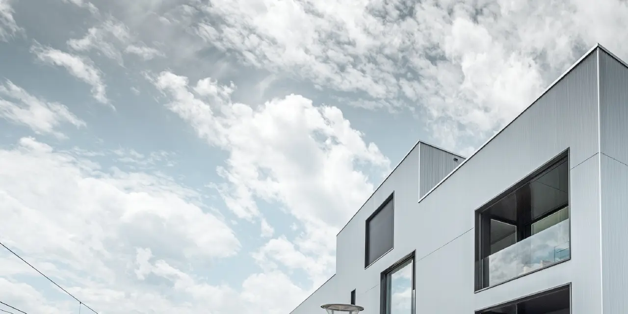 Moderno edificio aziendale con copertura piatta e facciata in alluminio; per la facciata è stato utilizzato il profilo a zeta PREFA anodizzato naturale.