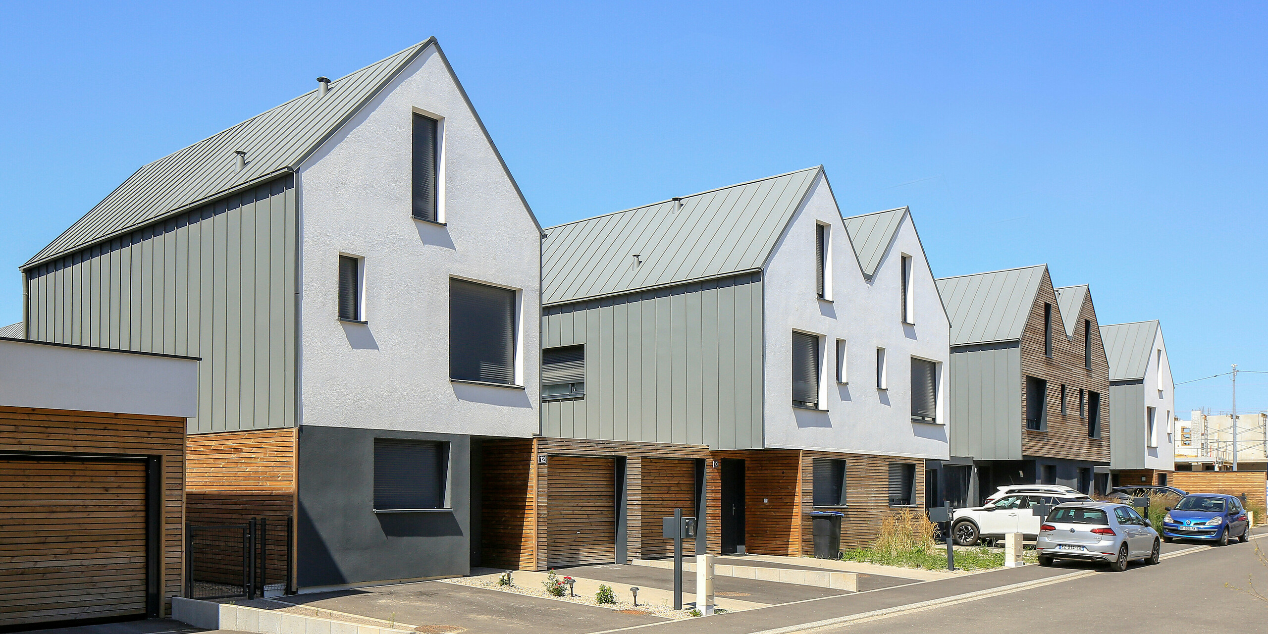 Le joint debout PREFALZ en gris souris s'étend sur les façades et les toits à pignon d'un lotissement mitoyen à Mundolsheim. Les coques uniformes du bâtiment en aluminium créent une image globale harmonieuse.