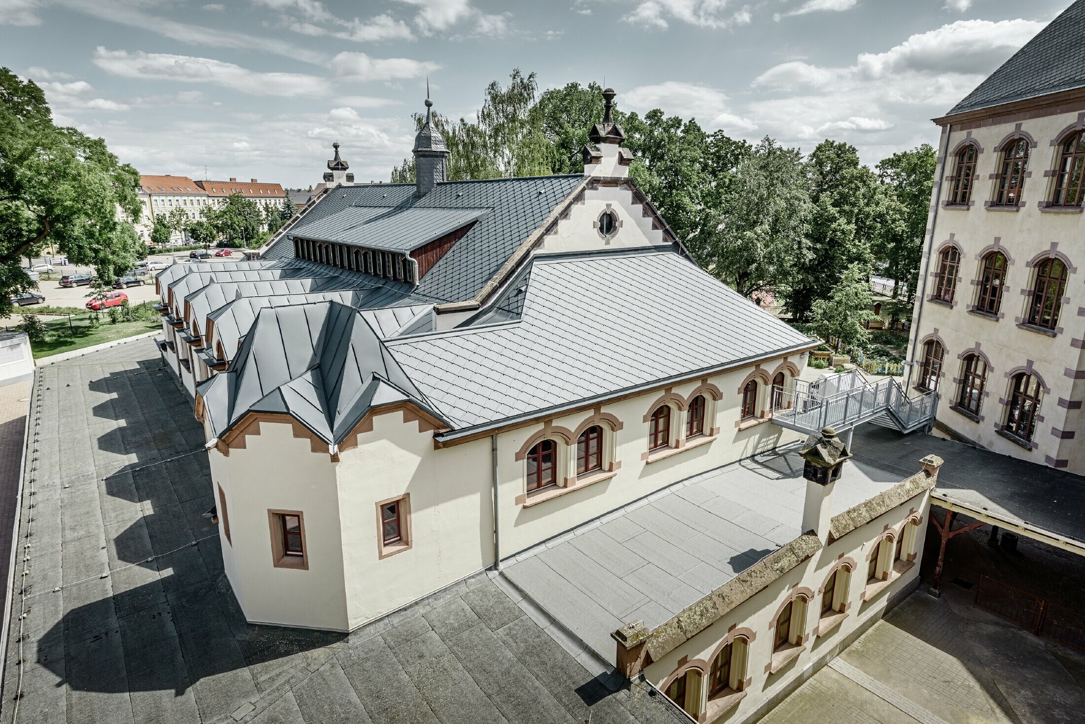 Salle de sport fraîchement rénovée de l’école de Lutherstadt Wittenberg — Toiture en aluminium PREFA réalisée avec des losanges de toiture et bandes Prefalz de couleur anthracite