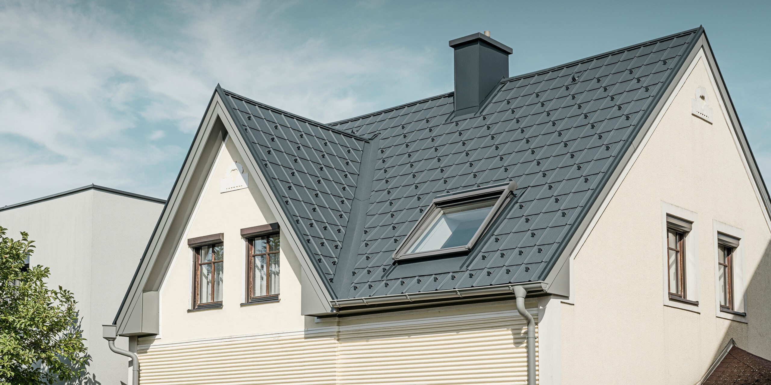 Einfamilienhaus in St. Valentin mit PREFA Dachplatte in anthrazit und einem Dachentwässerungssystem von PREFA in hellgrau