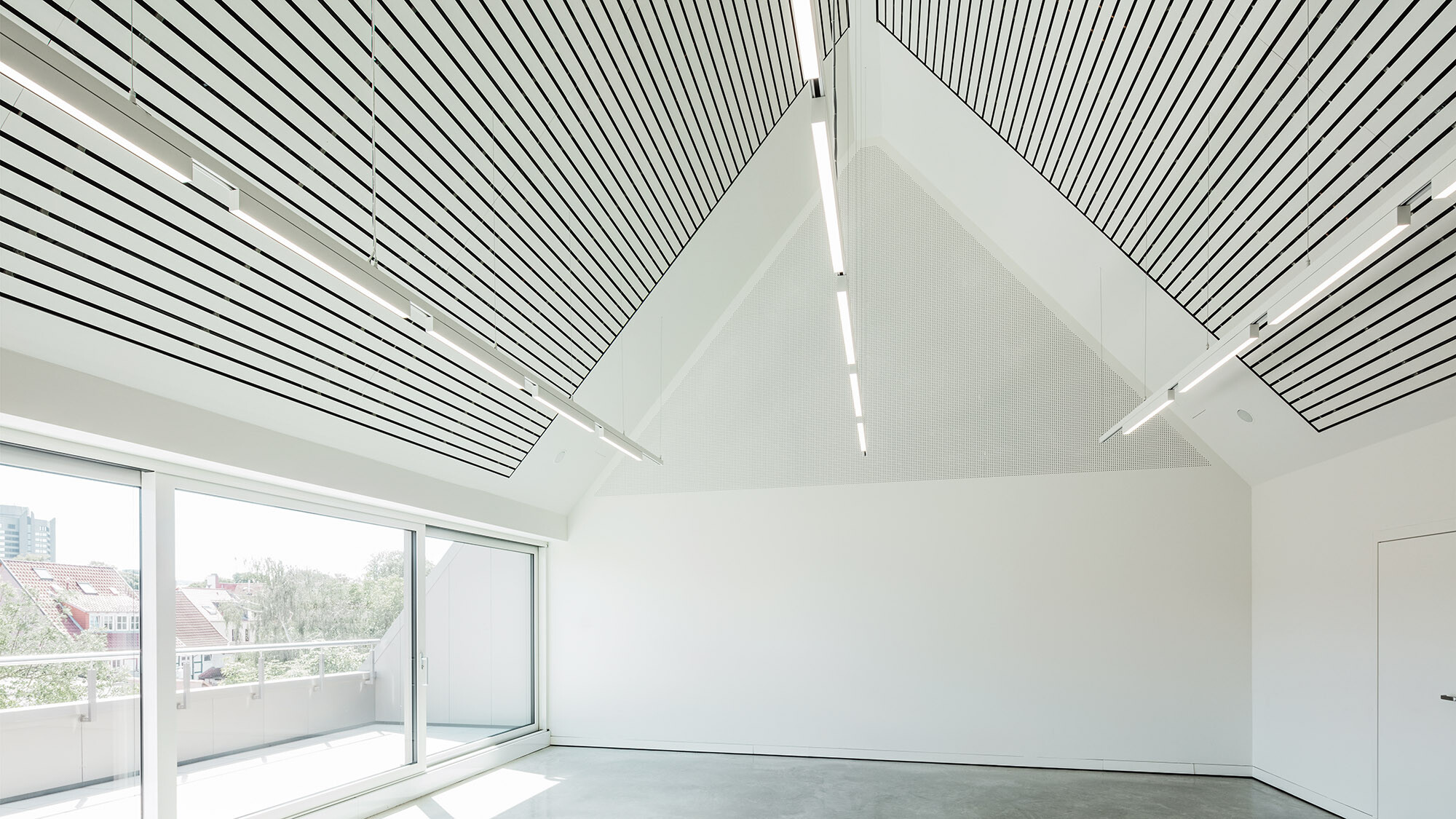 Ein Blick ins vollständig in Weiß gehaltene Interieur des Kunsthauses mit einer Beleuchtung an der Decke.